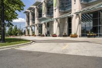 an empty parking lot with a canopy over the street, surrounded by many different planters and flowers