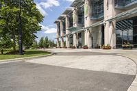 an empty parking lot with a canopy over the street, surrounded by many different planters and flowers