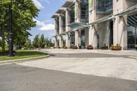 an empty parking lot with a canopy over the street, surrounded by many different planters and flowers