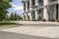 an empty parking lot with a canopy over the street, surrounded by many different planters and flowers