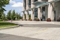 an empty parking lot with a canopy over the street, surrounded by many different planters and flowers