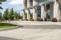 an empty parking lot with a canopy over the street, surrounded by many different planters and flowers