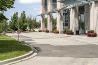 an empty parking lot with a canopy over the street, surrounded by many different planters and flowers