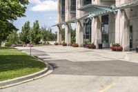 an empty parking lot with a canopy over the street, surrounded by many different planters and flowers