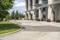 an empty parking lot with a canopy over the street, surrounded by many different planters and flowers