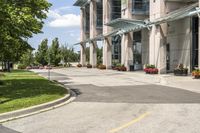 an empty parking lot with a canopy over the street, surrounded by many different planters and flowers