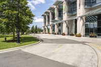 an empty parking lot with a canopy over the street, surrounded by many different planters and flowers