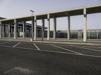 an empty parking lot with several cars parked in it and no one walking into the terminal