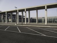 an empty parking lot with several cars parked in it and no one walking into the terminal