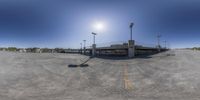 a fish - eye lens photo of a empty parking lot, the sun is shining down on it