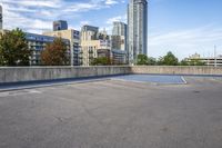 empty parking lot next to tall buildings with blue sky and clouds in the background in a city