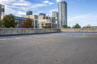 empty parking lot next to tall buildings with blue sky and clouds in the background in a city
