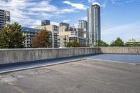 empty parking lot next to tall buildings with blue sky and clouds in the background in a city