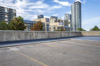 empty parking lot next to tall buildings with blue sky and clouds in the background in a city