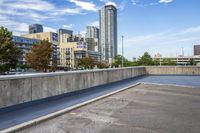 empty parking lot next to tall buildings with blue sky and clouds in the background in a city