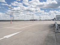 the empty parking lot is near some building and cloudy skies at daytimes time on the day