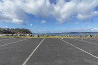 an empty parking lot with parked cars next to the beach and water as seen in a google street view