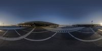 the empty parking lot has multiple curves around it and is reflected in a glass mirror