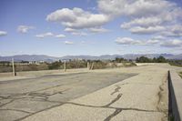 a view of a empty parking lot in the desert with a long pole on one corner