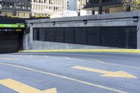 an empty parking lot with yellow arrows painted on it in the city center of a city