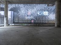 an empty parking lot with a fence and graffiti on it in front of an office building