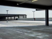 empty parking lot with open doors, no one on it, and light posts above the area