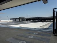 empty parking lot with open doors, no one on it, and light posts above the area