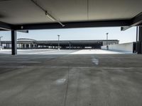 empty parking lot with open doors, no one on it, and light posts above the area