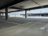 empty parking lot with open doors, no one on it, and light posts above the area