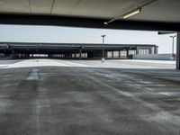 empty parking lot with open doors, no one on it, and light posts above the area