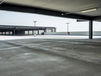 empty parking lot with open doors, no one on it, and light posts above the area