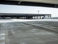 empty parking lot with open doors, no one on it, and light posts above the area