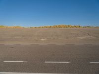 a empty parking lot with no people on it with clear blue skies above the area