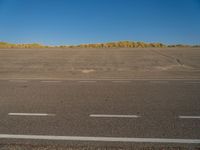 a empty parking lot with no people on it with clear blue skies above the area