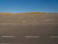 a empty parking lot with no people on it with clear blue skies above the area