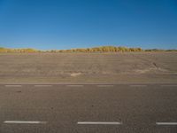 a empty parking lot with no people on it with clear blue skies above the area