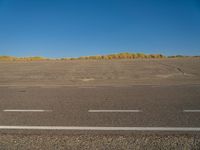 a empty parking lot with no people on it with clear blue skies above the area