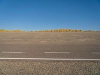 a empty parking lot with no people on it with clear blue skies above the area