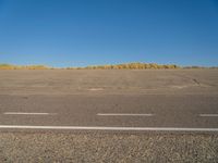 a empty parking lot with no people on it with clear blue skies above the area