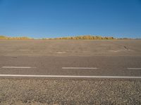 a empty parking lot with no people on it with clear blue skies above the area