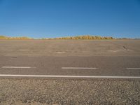 a empty parking lot with no people on it with clear blue skies above the area