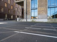 an empty parking lot that has been cleaned in front of an office building with a bicycle rack