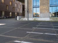 an empty parking lot that has been cleaned in front of an office building with a bicycle rack