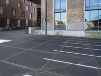 an empty parking lot that has been cleaned in front of an office building with a bicycle rack