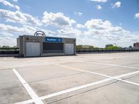 the empty parking lot is empty in the sunny day time and it looks like an old car garage