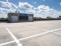 the empty parking lot is empty in the sunny day time and it looks like an old car garage