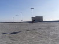 an empty parking lot with multiple posts and light poles in the background, on a sunny day