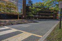 empty parking lot next to large building with reflection on building glass windows, in the shade