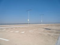 a empty parking lot with lines painted on it and a large sky over the ocean