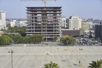 an empty parking lot in front of some tall buildings with palm trees in the foreground